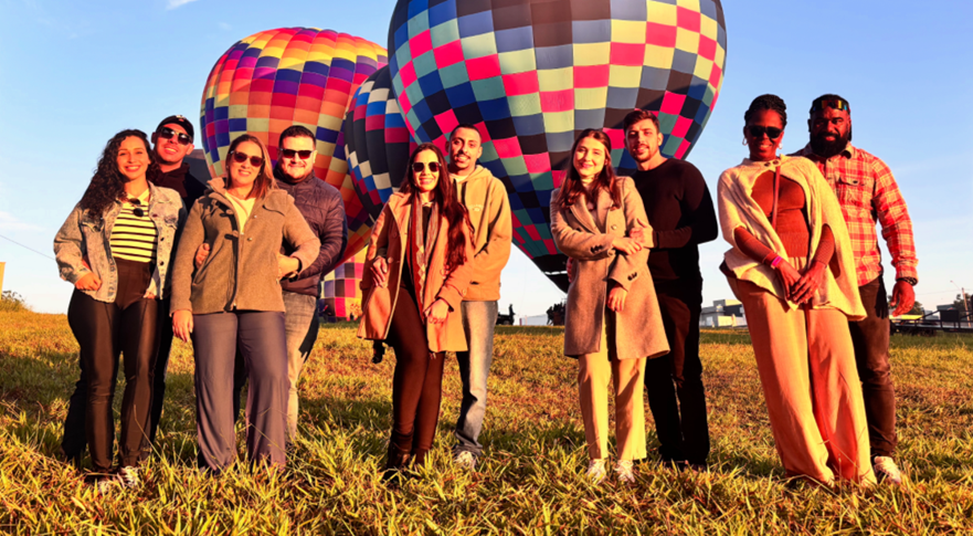 Família posando em frente ao balão colorido antes do voo em grupo
