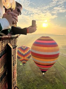 Passageiros fotografando outros balões durante o voo ao nascer do sol